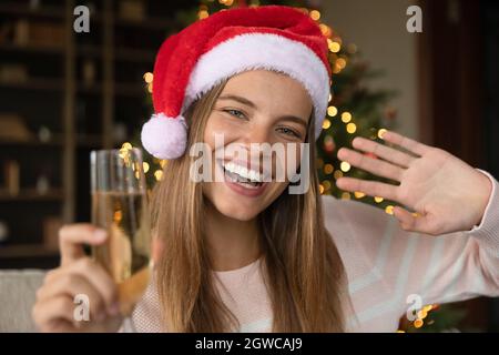 Happy Xmas Mädchen in roten Weihnachtsmann Hut winkt hallo Stockfoto