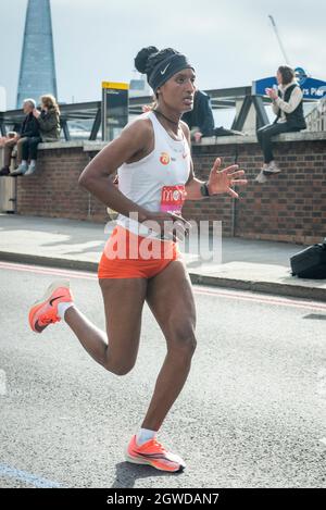 London, Großbritannien. Oktober 2021. Degitu AZIMERAW (ETH) übergibt beim London Marathon die Meile 24 bei Blackfriars, das erste Mal seit April 2019 aufgrund der Covid-19-Pandemie. Über 36,000 Spitzensportler, Clubläufer und Fun-Läufer nehmen an dem Massenevent Teil, weitere 40,000 Menschen nehmen virtuell Teil. Kredit: Stephen Chung/Alamy Live Nachrichten Stockfoto