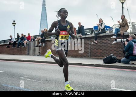 London, Großbritannien. Oktober 2021. Valary JEMELI (KEN) übergibt beim London-Marathon die 24 Meilen bei Blackfriars, das erste Mal seit April 2019 aufgrund der Covid-19-Pandemie. Über 36,000 Spitzensportler, Clubläufer und Fun-Läufer nehmen an dem Massenevent Teil, weitere 40,000 Menschen nehmen virtuell Teil. Kredit: Stephen Chung/Alamy Live Nachrichten Stockfoto