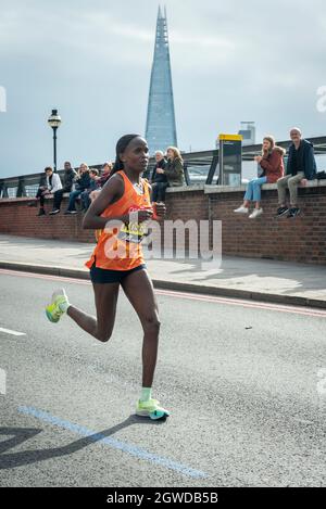 London, Großbritannien. Oktober 2021. Brigid KOSGEI (KEN) übergibt beim London Marathon die 24 Meilen bei Blackfriars, das erste Mal seit April 2019 aufgrund der Covid-19-Pandemie. Über 36,000 Spitzensportler, Clubläufer und Fun-Läufer nehmen an dem Massenevent Teil, weitere 40,000 Menschen nehmen virtuell Teil. Kredit: Stephen Chung/Alamy Live Nachrichten Stockfoto