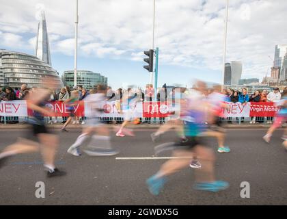 London, Großbritannien. Oktober 2021. Menschen, die beim London Marathon 2021 an der Tower Bridge Rennen. Quelle: SMPNEWS/Alamy Live News Stockfoto