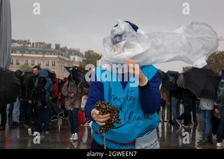 Paris, Frankreich, 3. Oktober 2021: Heftiger Regen am letzten Tag des Triumphbogens, eingewickelt von Christo und Jeanne-Claude, hielt die Massen nicht fern. Mit regenmacs und Sonnenschirmen strömten Touristen und Kunstliebhaber zum Place Charles de Gaulle, der für das Wochenende zur Fußgängerzone erklärt wurde. Viele posierten für Selfies. Andere haben sich die roten Seile und den silberfarbenen blauen Stoff genau angeschaut und die von Stewards verschenkte Musterquadrate weggenommen. Anna Watson/Alamy Live News Stockfoto