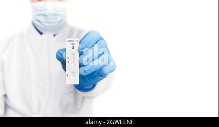 Der Arzt zeigt Covid-19-positives Testergebnis des Antigen-Schnelltest-Kits auf weißem Hintergrund, Copy Space, Coronavirus Infektiöse Protect-Konzept. Stockfoto