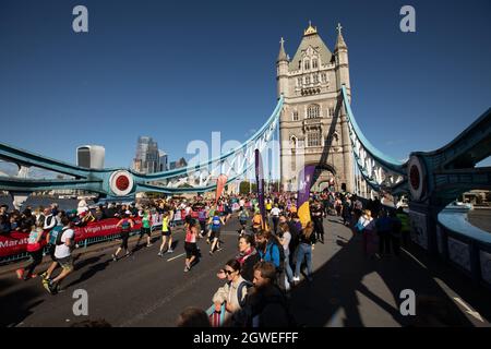 London, England. Oktober 2021. Menschen, die beim London Marathon 2021 an der Tower Bridge Rennen. Kredit: SMPNEWS / Alamy Live Nachrichten Stockfoto