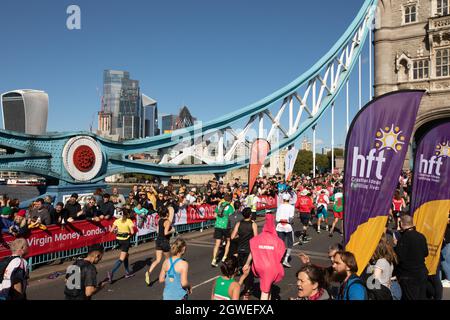 London, England. Oktober 2021. Menschen, die beim London Marathon 2021 an der Tower Bridge Rennen. Kredit: SMPNEWS / Alamy Live Nachrichten Stockfoto