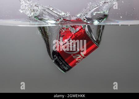 Nahaufnahme der Dose Coca Cola, die auf grauem Hintergrund in die Wasserisolation fällt. Schweden. Uppsals. Stockfoto
