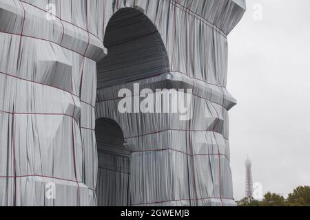 Paris, Frankreich, 3. Oktober 2021: Heftiger Regen am letzten Tag des Triumphbogens, eingewickelt von Christo und Jeanne-Claude, hielt die Massen nicht fern. Mit regenmacs und Sonnenschirmen strömten Touristen und Kunstliebhaber zum Place Charles de Gaulle, der für das Wochenende zur Fußgängerzone erklärt wurde. Der Eiffelturm war in der Ferne, mit seinem Gipfel in den Wolken. Anna Watson/Alamy Live News Stockfoto