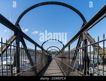 Alte Fußgängerbrücke aus Holz und Eisen über Dampfeisenbahn-Gleise in South Devon Stockfoto