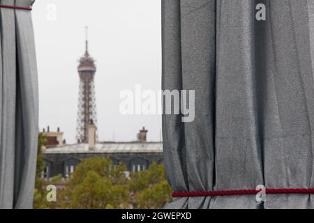 Paris, Frankreich, 3. Oktober 2021: Heftiger Regen am letzten Tag des Triumphbogens, eingewickelt von Christo und Jeanne-Claude, hielt die Massen nicht fern. Mit regenmacs und Sonnenschirmen strömten Touristen und Kunstliebhaber zum Place Charles de Gaulle, der für das Wochenende zur Fußgängerzone erklärt wurde. Der Eiffelturm war in der Ferne, mit seinem Gipfel in den Wolken. Anna Watson/Alamy Live News Stockfoto