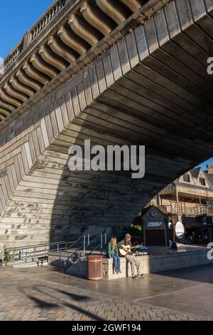 Ein Straßenmusiker spielt Gitarre und singt unter der London Bridge in Lake Havasu City, Arizona. Stockfoto