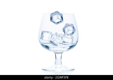 Eiswürfel auf leeres Snifter- oder Ballonglas auf weißem Hintergrund abtropfen lassen, Getränkekonzept Stockfoto