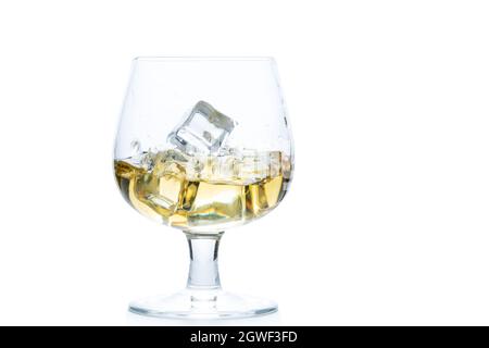 Whiskey oder Brandy mit Eis in Snifter- oder Ballonglas isoliert auf weißem Hintergrund, Getränkekonzept Stockfoto