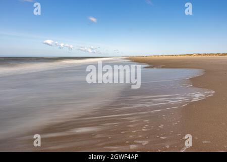 Leerer brauner Sandstrand mit im Meer und dem Horizont im Hintergrund, sonniger Frühlingstag mit einem klaren blauen Himmel in Petten aan Zee, Noord-Holland in t Stockfoto