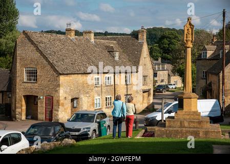 Guiting Power, Gloucestershire, England, Großbritannien. 2021. Guiting Power wählte eines der besten Dörfer Englands. Dorfzentrum mit einem älteren Paar, das towa läuft Stockfoto