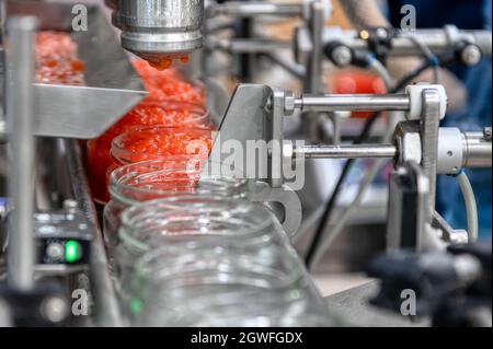 Maschine zum Befüllen von rotem Kaviar in Glasgefäße. Abfüllanlagen, Lebensmittelindustrie Stockfoto