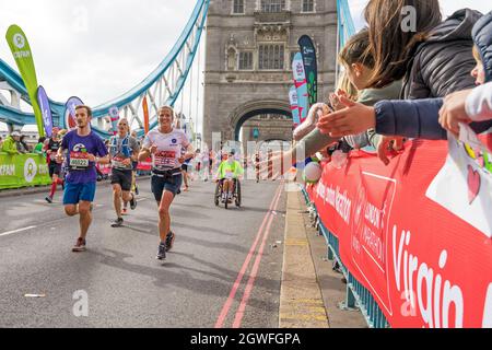 Läufer, die den 41. London Marathon absolvieren, laufen über die Tower Bridge. London - 3. Oktober 2021 Stockfoto