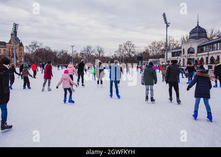 BUDAPEST, UNGARN - 31. DEZEMBER 2018: Viele Menschen verbringen ihren Urlaub Schlittschuhlaufen in City Park Eisbahn in Budapest, Ungarn. Der Stadtpark ist Europas größte Stadt Stockfoto