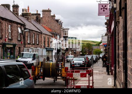 Die Hauptstraße durch die kleine Marktstadt Wooler mit vielen Geschäften und Pubs, beliebt bei Spaziergängern und als das Tor zu den Cheviots bezeichnet Stockfoto