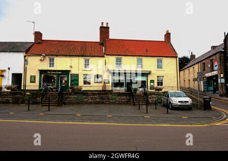 Die Hauptstraße durch die kleine Marktstadt Wooler mit vielen Geschäften und Pubs, beliebt bei Spaziergängern und als das Tor zu den Cheviots bezeichnet Stockfoto