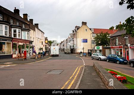 Die Hauptstraße durch die kleine Marktstadt Wooler mit vielen Geschäften und Pubs, beliebt bei Spaziergängern und als das Tor zu den Cheviots bezeichnet Stockfoto