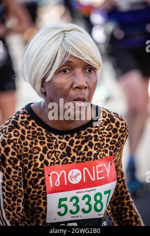 London, England. Oktober 2021. Eine ältere Dame, die ein Oberteil mit Leopardenmuster trägt, lief beim London Marathon 2021 auf der Tower Bridge in London, England. Kredit: SMPNEWS / Alamy Live Nachrichten Stockfoto