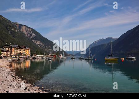 Ufer des Achensees im Dorf Pertisau in Tirol. Schöne Aussicht auf die ruhige Szene des Achensee mit Yacht im Sommer. Stockfoto