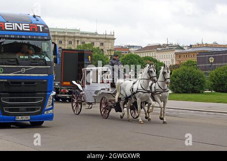 WIEN, ÖSTERREICH - 15. MAI 2019: Eine alte Pferdekutsche überholt moderne Fahrzeuge auf den Straßen der historischen Stadt Stockfoto