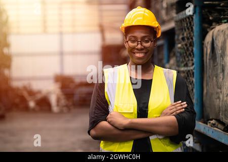 Porträt Schwarze smarte afrikanische Arbeiterinnen, die am Arbeitsplatz der Fabrikindustrie glücklich lächeln Stockfoto