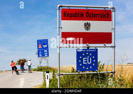 Menschen auf Fahrrädern Grenzen, Grenzübertritt nach Österreich, EU-Zeichen, Sommerurlaub Stockfoto