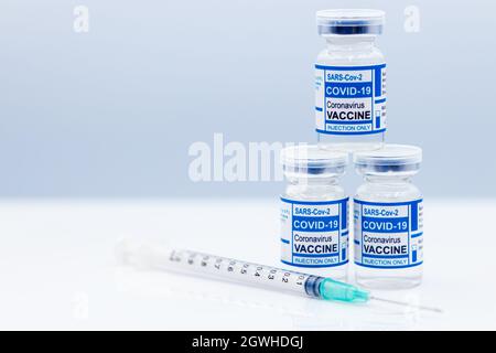 Covid-Impfstoffflasche mit Coronavirus (COVID-19) und medizinische Nadelspritze mit Platz für Text. Stockfoto