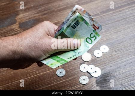 Oslo, Norwegen. September 2021. Einige norwegische Kronen-Scheine und Münzen in der Hand Stockfoto