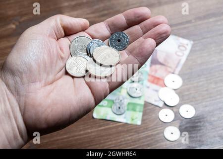 Oslo, Norwegen. September 2021. Einige norwegische Kronen-Scheine und Münzen in der Hand Stockfoto