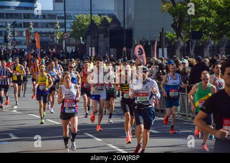 London, Großbritannien. Oktober 2021. Läufer passieren den Parliament Square während des London Marathon 2021. Stockfoto