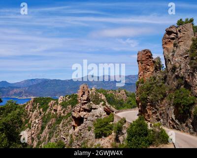 Die landschaftlich reizvolle D81 schlängelt sich durch die roten Klippen der Calanche, die zum UNESCO-Weltkulturerbe gehört. Korsika, Frankreich. Stockfoto