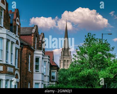 Fassade aus englischen Reihenhäusern und Bäumen vor der gotischen Kirche unserer Lieben Frau und der englischen Märtyrer in Cambridge, England Stockfoto