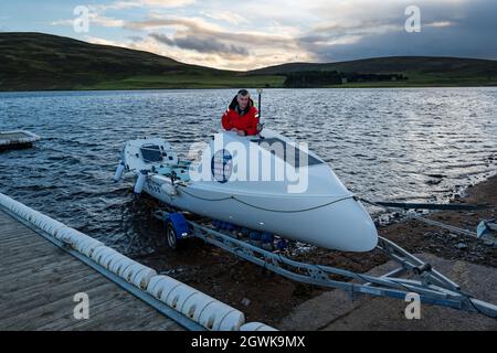 Männer starten ein Ruderboot auf dem Whitesadder Reservoir für ein Training für Atlantic Challenge, East Lothian, Schottland, Großbritannien Stockfoto