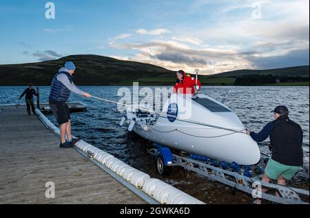 Männer starten ein Ruderboot auf dem Whitesadder Reservoir für ein Training für Atlantic Challenge, East Lothian, Schottland, Großbritannien Stockfoto