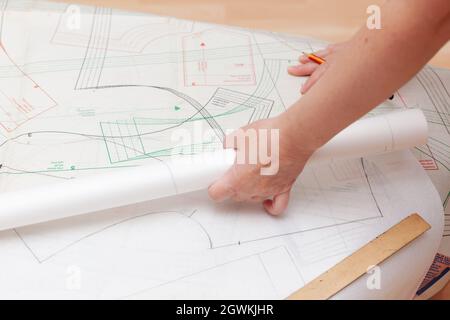 Weibliche Hände machen das Layout des Nähmusters auf Papier Stockfoto