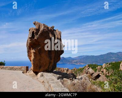 Die D81 schlängelt sich durch die Calanche, UNESCO. Freistehender Felsen mit dem Golf von Porto im Hintergrund. Korsika Stockfoto
