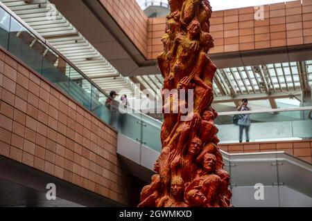 Hongkong, Hongkong SAR. Oktober 2021. Die Schüler schauen von einer nahen Treppe auf die Säule der Schande herab. Die acht Meter hohe Säule der Schande erinnert an studentische Demonstranten, die während des Massakers auf dem Platz des Himmlischen Friedens ihr Leben verloren haben. Die vom dänischen Künstler Jens Galschiot geschaffene Statue ist seit der ersten Mahnwache am 4. Juni 1997 an der Universität Hongkong präsent. (Bild: © Katherine Cheng/SOPA Images via ZUMA Press Wire) Bild: ZUMA Press, Inc./Alamy Live News Stockfoto