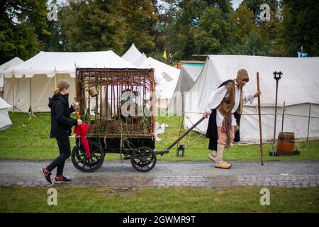 03. Oktober 2021, Nordrhein-Westfalen, Lüdinghausen: Ein mittelalterlich gekleideter Performer zieht auf dem Gelände von Annotopia einen Anhänger mit einem als Vogel gekleideten Performer. Zahlreiche verkleidete Besucher wurden zum zweitägigen Fantasy-Festival erwartet. Foto: Lino Mirgeler/dpa Stockfoto