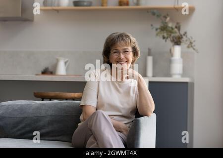 Porträt einer lächelnden älteren, pensionierten Frau in einer Brille. Stockfoto
