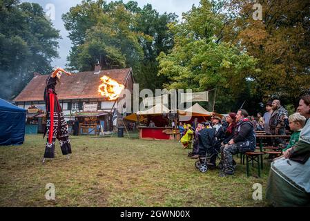 03. Oktober 2021, Nordrhein-Westfalen, Lüdinghausen: Eine Feuerkünstlerin, die auf Stelzen läuft, handhabt auf dem Gelände von Annotopia einen Feuerball. Zahlreiche verkleidete Besucher wurden zum zweitägigen Fantasy-Festival erwartet. Foto: Lino Mirgeler/dpa Stockfoto