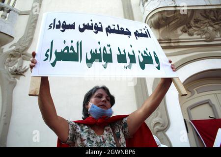 Ein Demonstranten hält während einer Kundgebung an der Habib Bourguiba Avenue in Tunis ein Plakat mit Slogans hoch. Tausende versammelten sich zur Unterstützung von Präsident Kais Saied, nachdem er die Legislaturperiode suspendiert, die Regierung entlassen und die Kontrolle über die Justiz übernommen hatte, um später per Dekret zu regieren. Stockfoto