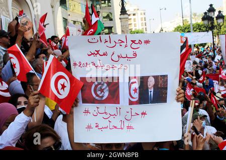 Ein Demonstranten hält während einer Kundgebung an der Habib Bourguiba Avenue in Tunis ein Plakat mit Slogans hoch. Tausende versammelten sich zur Unterstützung von Präsident Kais Saied, nachdem er die Legislaturperiode suspendiert, die Regierung entlassen und die Kontrolle über die Justiz übernommen hatte, um später per Dekret zu regieren. Stockfoto