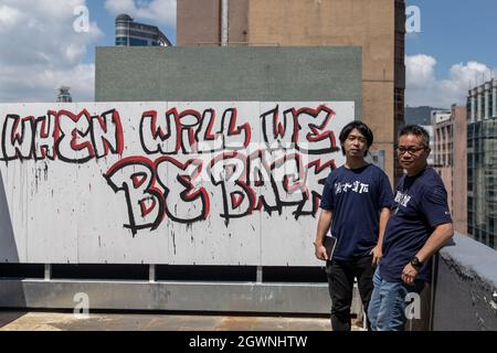 Der Vorsitzende der HKCTU, Joe Wong Nai-yuen (R), und der stellvertretende Vorsitzende, Leo Tang Kin-wah (L), posieren nach der Pressekonferenz der letzten Ausstellung der Gewerkschaft für ein Foto mit einem Graffiti mit der Aufschrift „When will we be back“, das ihren 31-jährigen Kampf für die Arbeitnehmerrechte zeigt. Die größte oppositionelle Gewerkschaft Hongkongs, die Hongkonger Gewerkschaftsföderation (HKCTU), hat am 4. Oktober eine Sondersitzung durchgeführt und die Abstimmung über die Auflösung angenommen, da 57 Stimmen zustimmen, 8 Stimmen dagegen sind und 2 leer sind, was ihre 31-jährige Dienstzeit seit 1990 beendet. Nach einer Kehrtkneigung gegen das Töten von Dissens aus C Stockfoto