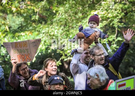 London, Großbritannien. Oktober 2021. Ein Mann hebt ein kleines Kind vorsichtig in die Luft, während eine Frau in der Gruppe ein Schild mit dem Namen „Run Daty Fox“ hochhält, das den Jungen zu einem „Baby Fox“ machen könnte. Zuschauer beobachten den Virgin London Marathon 2021. Kredit: Imageplotter/Alamy Live Nachrichten Stockfoto