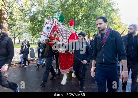 Ein Mann sah, wie er das zeremonielle Pferd Zuljanah durch den marsch führte.Imam Hussain, der Enkel des Propheten Muhammad, wurde am 10 680. Oktober n. Chr. wegen des Kampfes gegen die Tyrannei Yazids im Irak gemartert. Im Laufe der Jahre fand ein Marsch statt, um Hussain für sein Martyrium als Teil der Hussain Solidarity Movement zu gedenken. In London, veranstaltet vom Hussaini Islamic Trust UK, versammelten sich Muslime, beteten am Marble Arch und marschierten später zur Park Lane. Die Teilnehmer nutzten auch die Gelegenheit, ihre Solidarität mit der Gleichstellung der Geschlechter, der Freiheit und dem Frieden wiederherzustellen. Stockfoto