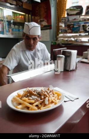 Ein Teller mit griechischem Poutine mit Feta-Käse, eine Art kultiges kanadisches Gericht, das in einem traditionellen Restaurant in Toronto, Ontario, Kanada, serviert wird. Stockfoto