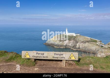 Holy Island, Wales: Leuchtturm South Stack (Ynys lawd) vor der Nordwestküste von Anglesey. Warnschild am Klippenrand. Stockfoto